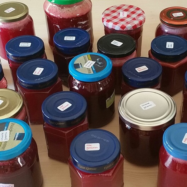 Abbildung von mit roter Marmelade gefüllten Gläsern mit kleinen Etiketten auf dem Deckel